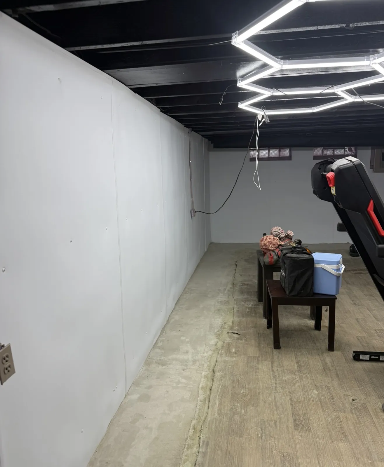 Basement with white wall liner installed along the perimeter and the floor edge restored